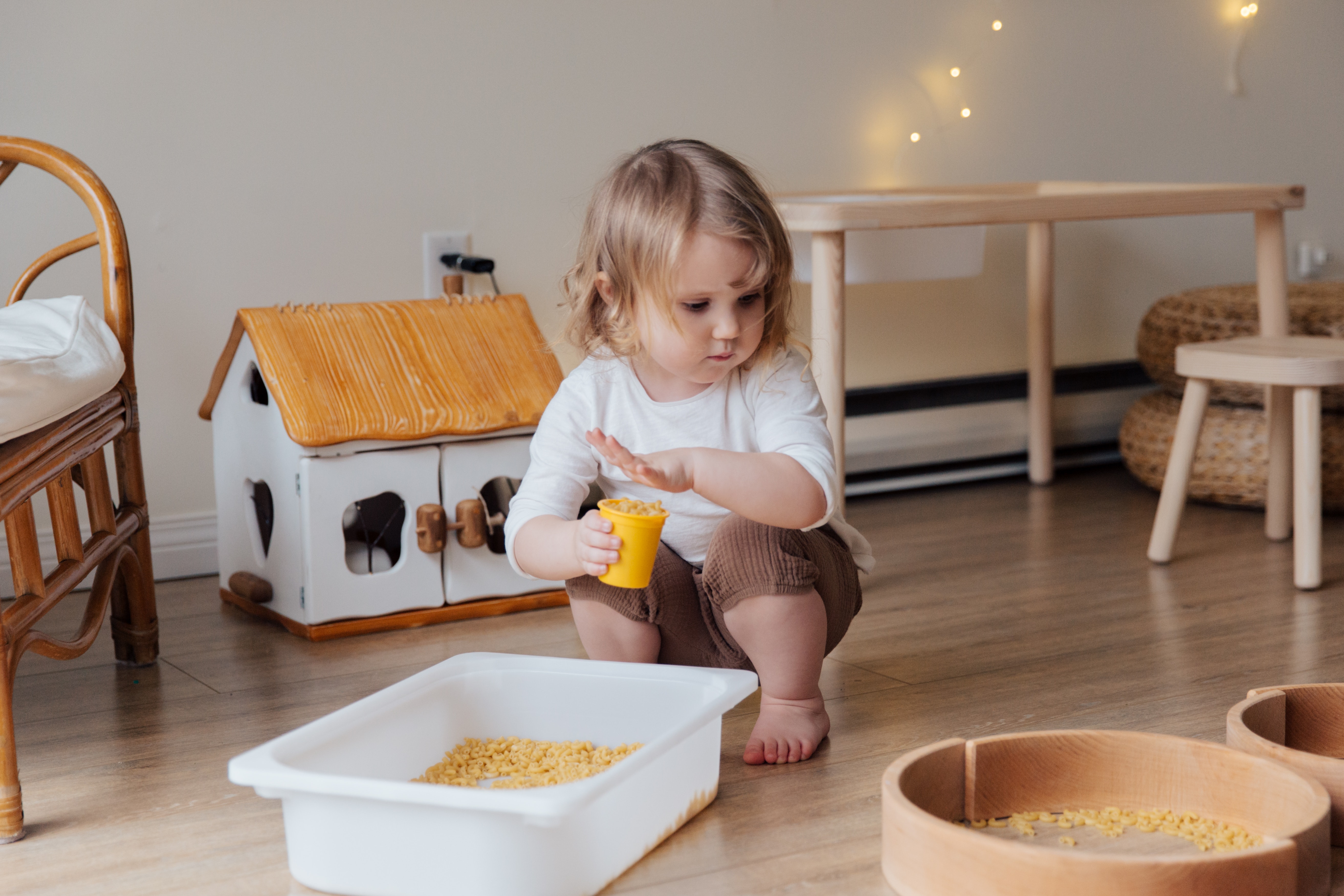 girl holding yellow plastic cup full of macaroni 3933271