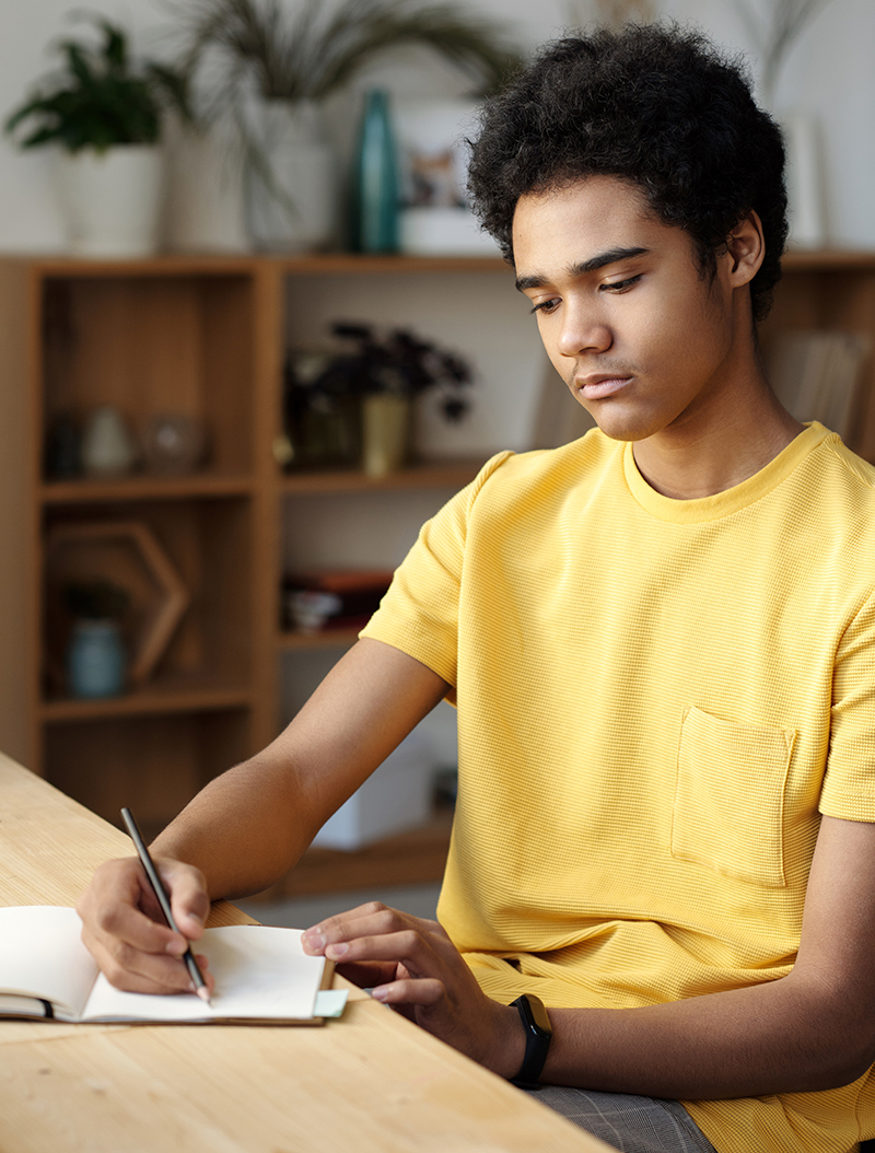 teenager writing down in journal